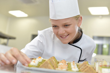 Young caterer preparing tray of appetizers