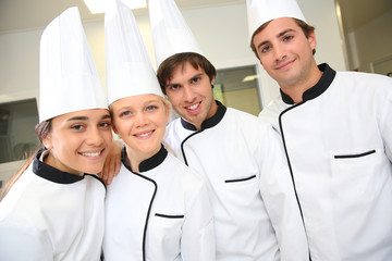 Team of future restaurant chefs looking at camera