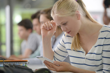High-school girl using smartphone in class
