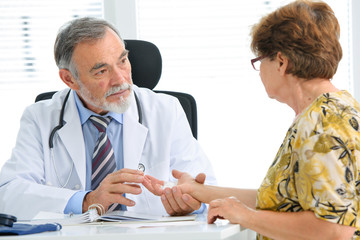 Arzt untersucht verletzte Hand der Patientin