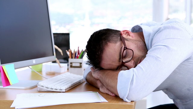 Creative designer napping on his desk