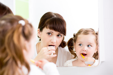 mother teaching kid teeth brushing