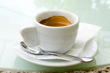 White espresso cup standing on the table of the street cafe
