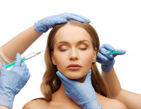 woman face and beautician hands with syringe