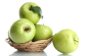 Ripe green apples with leaves in basket isolated on white