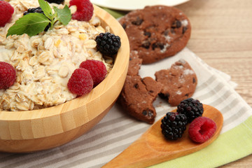 tasty oatmeal with berries, on wooden table
