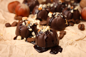 Chocolate candies and coffee beans, on beige paper background