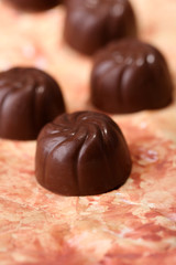 Chocolate candies with nuts, on color background