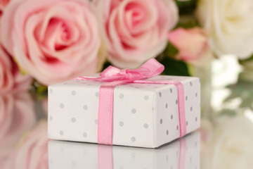 Beautiful gift on flowers background isolated on white