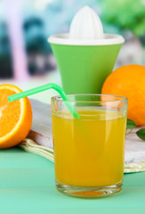 Glass of juice, citrus press and ripe orange