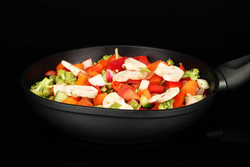 Vegetable ragout in pan, isolated on black