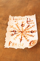 Old paper with symbols, on wooden background