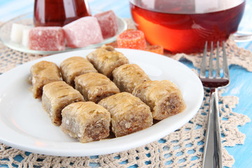 Sweet baklava on plate with tea on table
