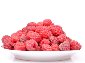 Group of fresh raspberries on plate isolated on white background
