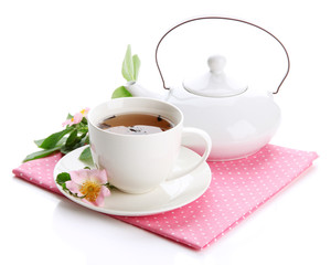 Cup and teapot of herbal tea with hip rose flowers, isolated