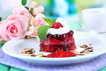 Tasty jelly dessert with fresh berries, on bright background