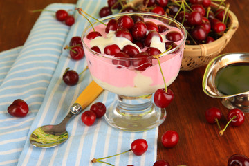 Delicious cherry dessert in glass vase on wooden table close-up