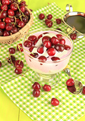 Delicious cherry dessert in glass vase on wooden table close-up