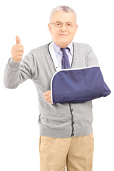 Senior man with broken arm giving thumb up