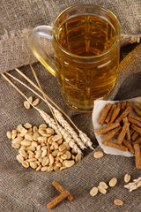Beer in glass, crackers and nuts on bagging on wooden table
