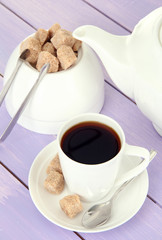 Cup of coffee, teapot and sugar-bowl on color wooden background