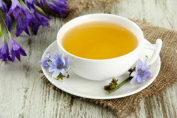 Cup of tea with chicory, on wooden background