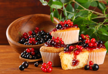 Tasty muffins with berries on wooden table