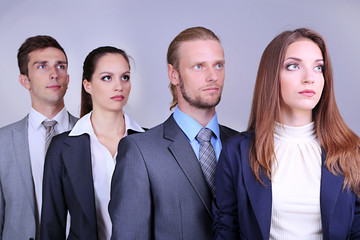 Business team standing in row on grey background