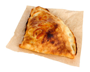 Pizza calzone on tracing paper isolated on white