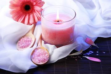 Beautiful pink candle with flower on bamboo mat