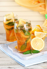 Iced tea with lemon and mint on wooden table