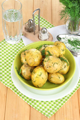 Boiled potatoes on platens on on napkins on wooden table