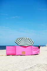 Beach wind shelter and parasol on the beach 