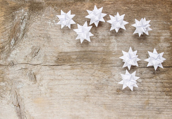 Paper stars on wooden rough background. Copy space