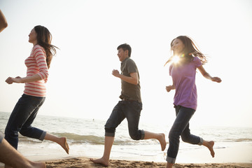 Naklejka premium Friends Running at the Beach