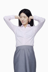 Businesswoman covering ears with hands