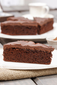 Chocolate cake on white plate, on hessian.