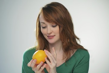 Young woman holding an orange