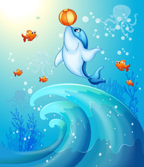 Naklejka premium A dolphin playing a ball under the sea