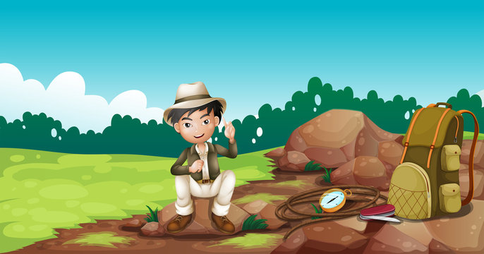 A boy wearing a hat sitting on a rock