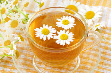 Obraz na płótnie Canvas Cup of tea with chamomile flowers