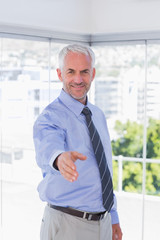Fototapeta premium Smiling businessman extending arm for handshake