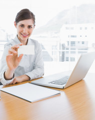 Pretty businesswoman showing blank business card