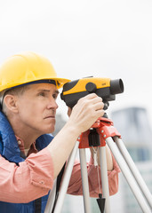 Construction Worker Measuring Distances Through Theodolite