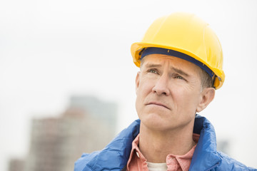 Tired Worker Looking Away At Construction Site