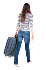 Naklejka premium back view of walking woman with suitcase.