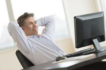 Businessman Relaxing While Looking At Desktop Pc