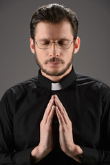 Priest praying to God. Portrait of priest praying while standing