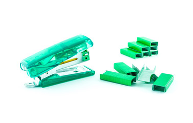 Green stapler and bunch of staples isolated on white