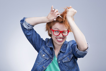 young woman cuts her hair with scissors Hairdressing